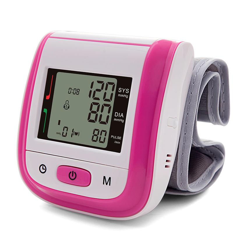 Bright magenta pink and white wrist blood pressure monitor in 3/4 view showing cuff positioning and device proportions