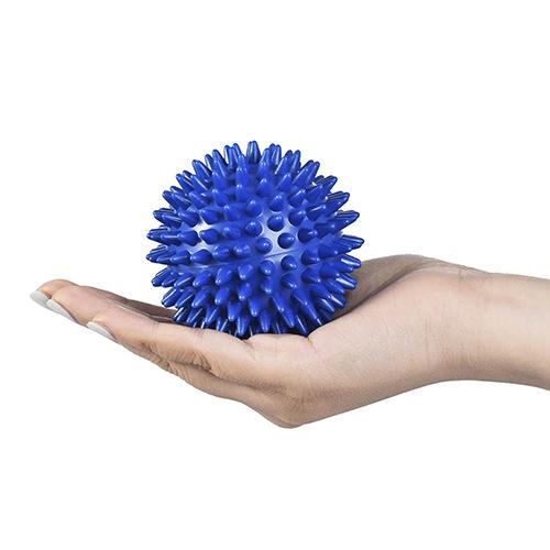 Hand holding massage ball demonstrating compact size and ergonomic grip potential
