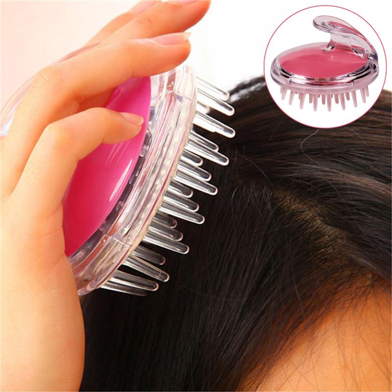 Hand holding pink brush against hair roots