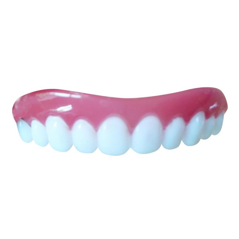 Angled view of lower veneer set in coral pink gum with white tooth veneers on light concrete