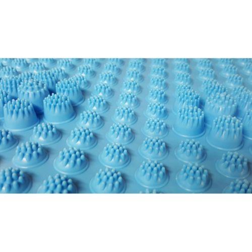 Extreme close-up macro photograph of blue mat surface showing thousands of individually-molded acupressure nodules in a precise grid pattern