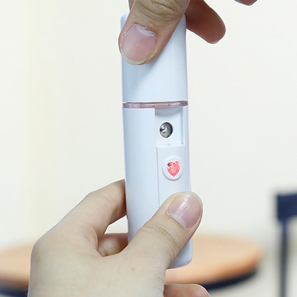 Woman holding steamer while misting her face, skin looking hydrated and refreshed.