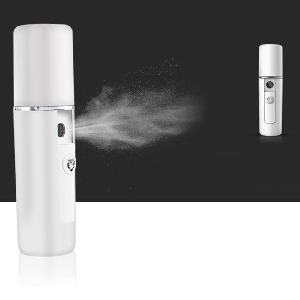 Large steamer unit spraying visible nano mist cloud with compact handheld unit shown at right, demonstrating misting effectiveness and portability.