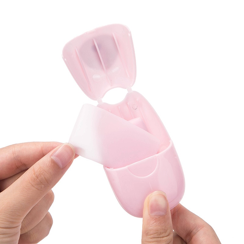 Flip-top dispenser opened, a single white soap sheet being pulled out for use