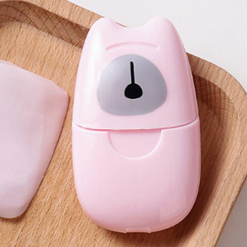 Pastel pink paper soap dispenser and refill case on a natural wood surface, modern and portable