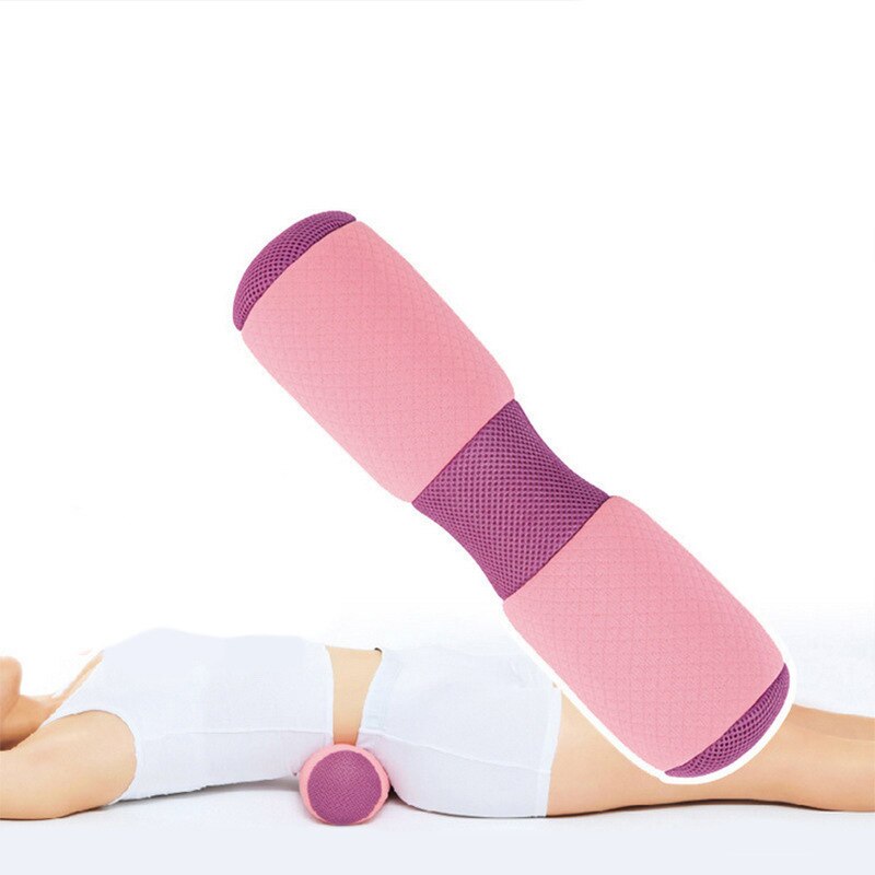 Woman using pink bolster for leg and lumbar support during floor exercise