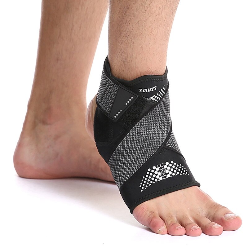 Gray mesh brace with white dotted accents on male foot showing compression wrapping design