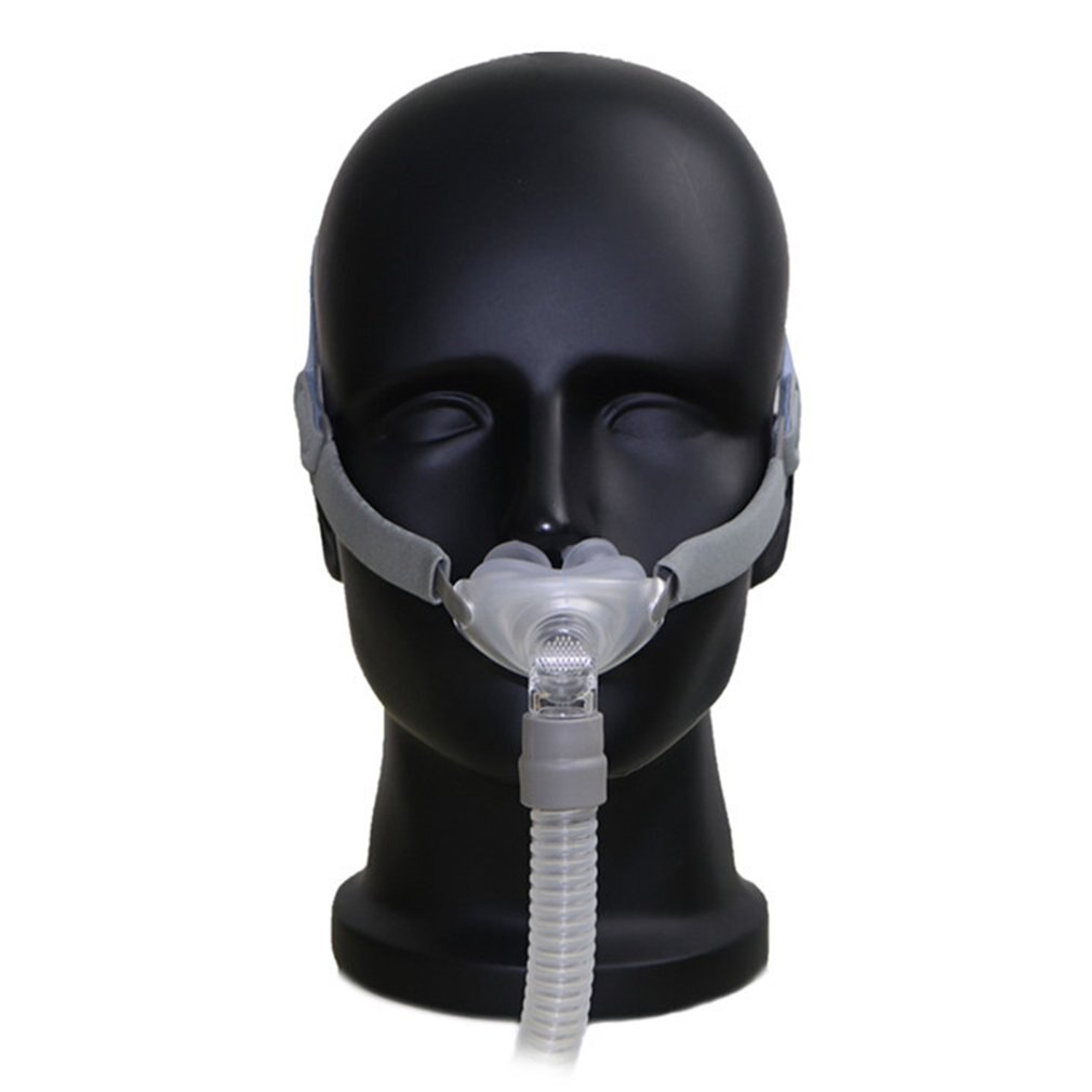 Nasal pillow CPAP mask positioned on a mannequin, showing clear silicone cushion and dual head straps.