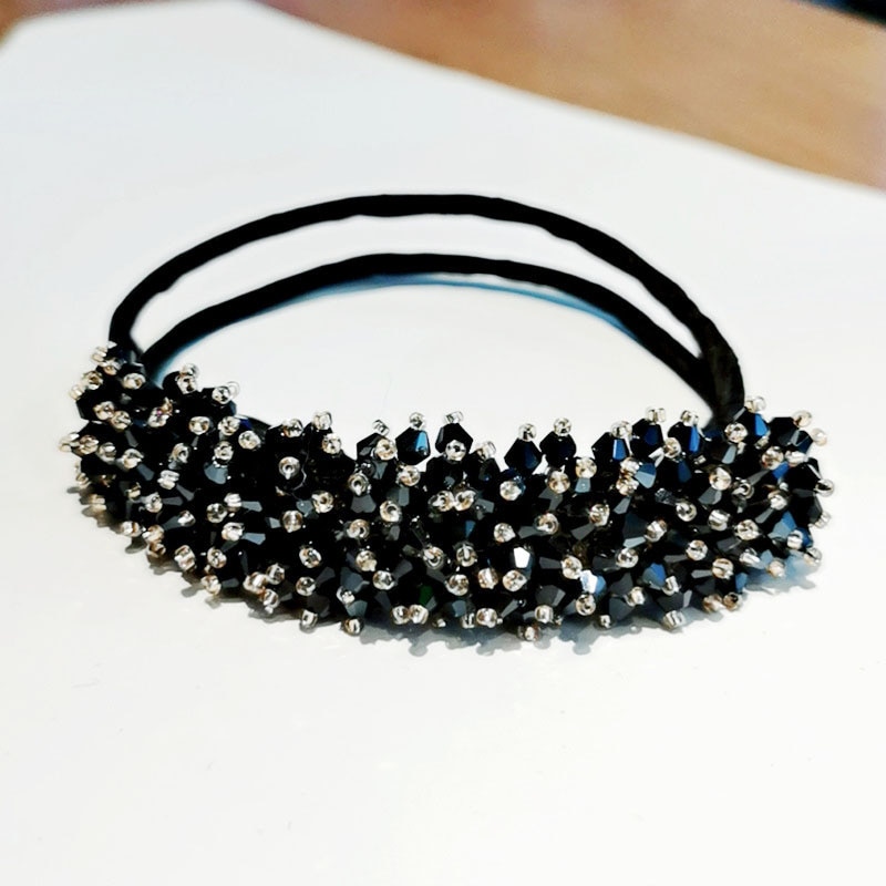 Dense faceted beadwork across a flexible black hair band