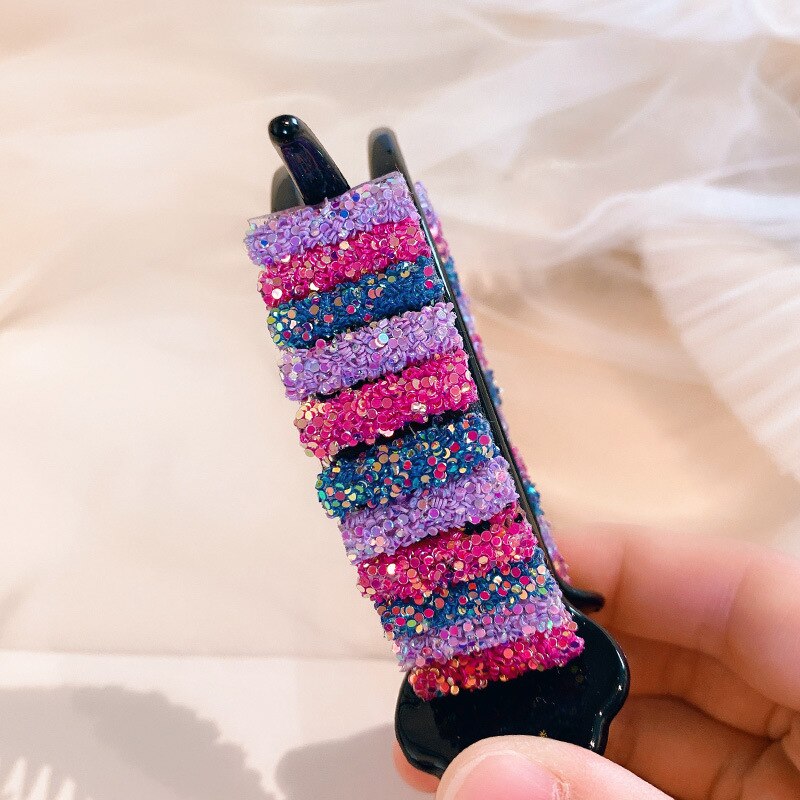 Glossy black base beneath layered rainbow decoration