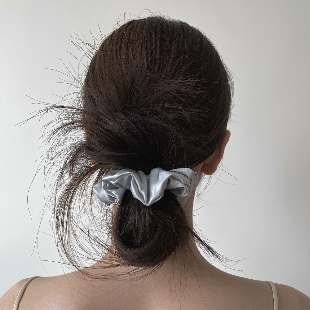 Silver scrunchie worn around a low bun