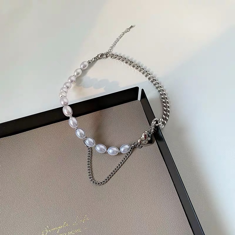 This chic Pearl & Metal Chain Heart Choker is crafted from a combination of metal and pearl chains that provide a luxuriously sophisticated look. The heart-shaped pendant adds a stylish, eye-catching detail that makes this piece a must-have accessory. Its adjustable chain ensures a comfortable, snug fit.