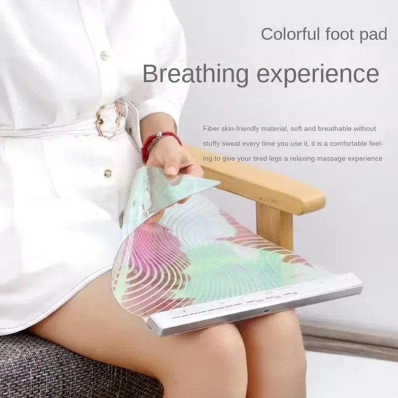 Woman in white shirt using the foot pad on her legs while sitting, showing breathable fabric and comfortable user experience