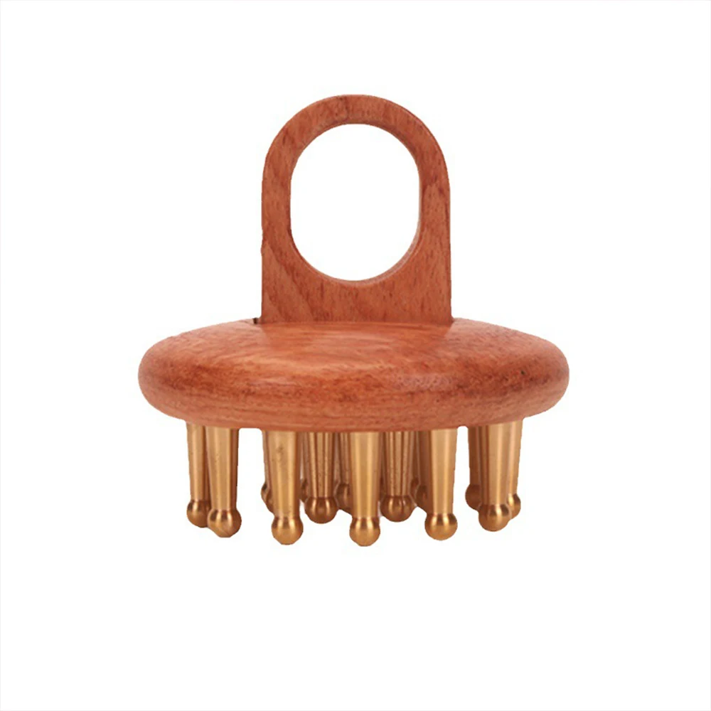 Copper wood head massage comb with brass prongs and ergonomic handle loop on cream linen