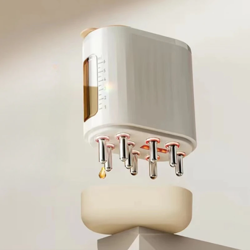 EMS Scalp Massager with eight nozzles dispensing golden liquid, mounted on cream-colored base