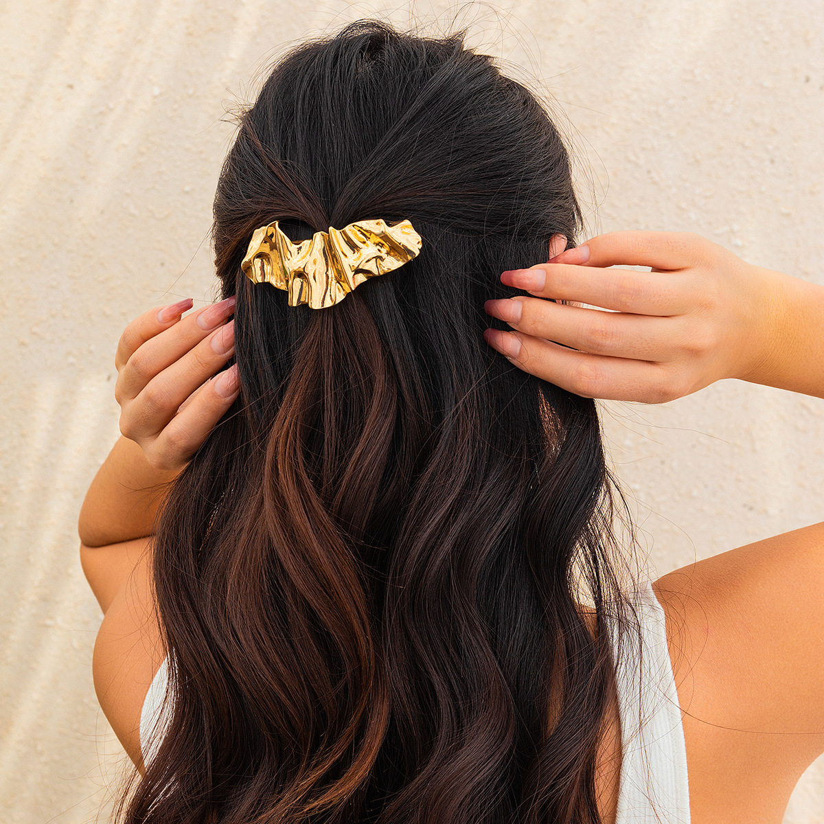 Woman adjusting gold clip in long dark hair