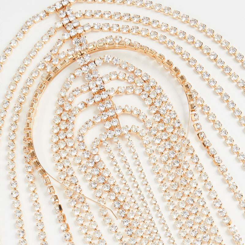 Close-up of faceted stones and layered gold chainwork