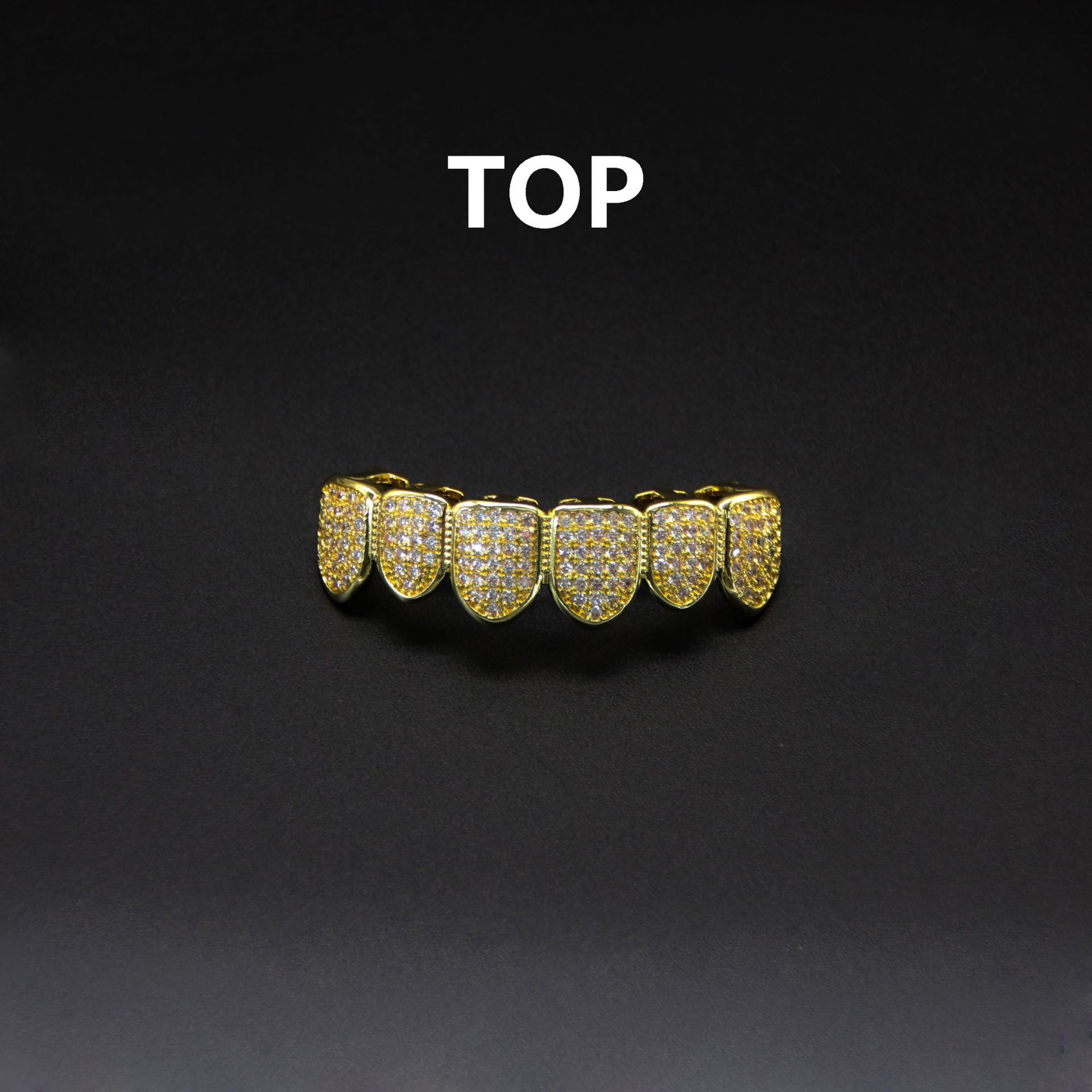 Single gold top grillz piece labeled TOP on dark background showing underside snap-fit clips