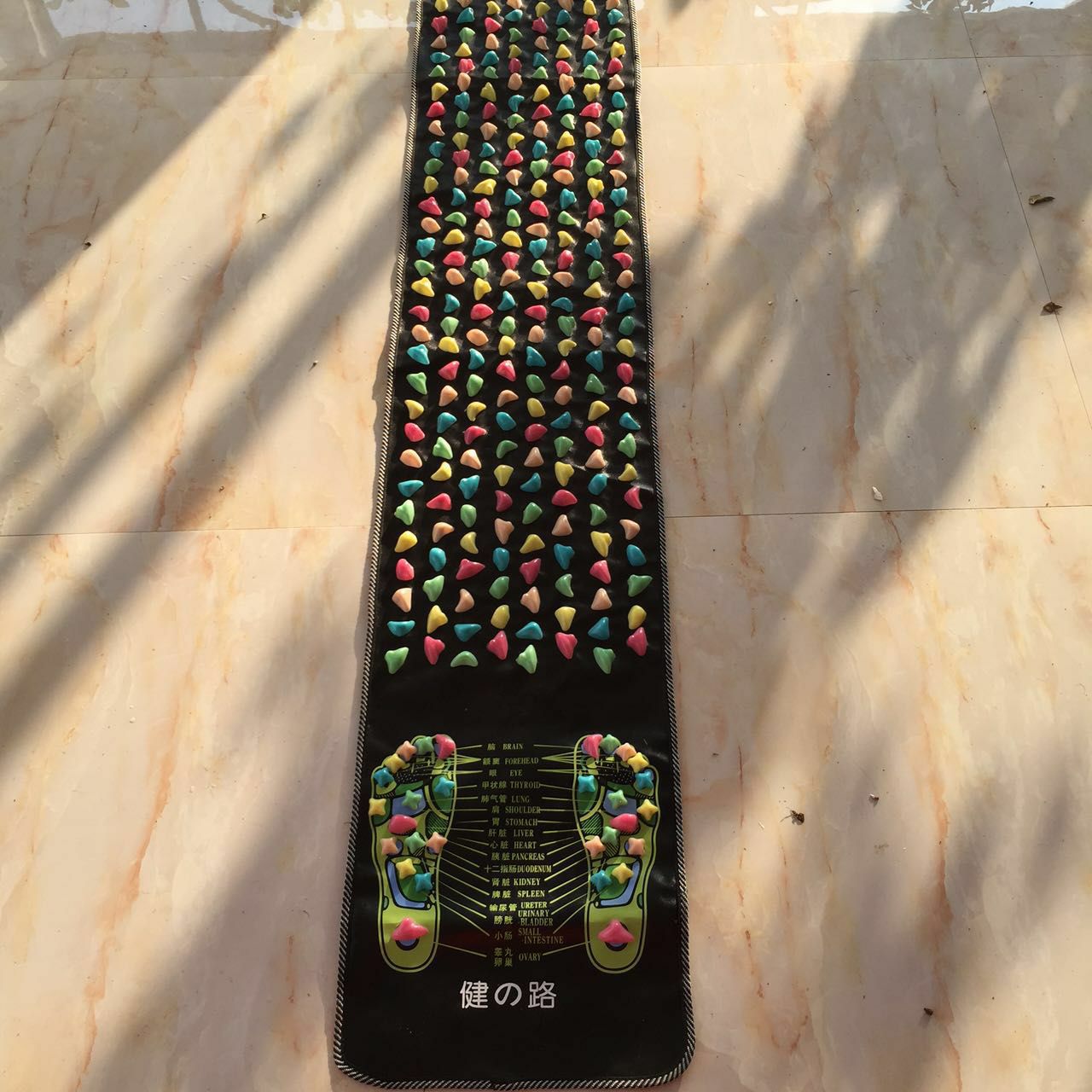Full-length foot massage carpet placed in a bright living space for daily wellness routine with colored nodes spanning the entire surface