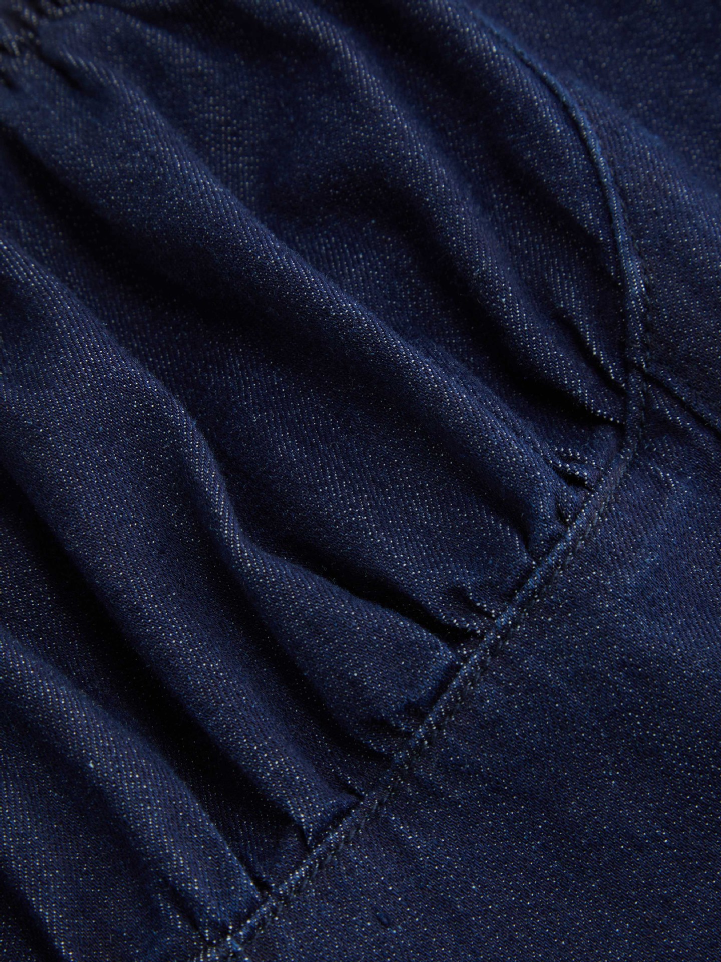 Deep blue one-shoulder mini dress detail shot – button splicing and fitted silhouette close-up