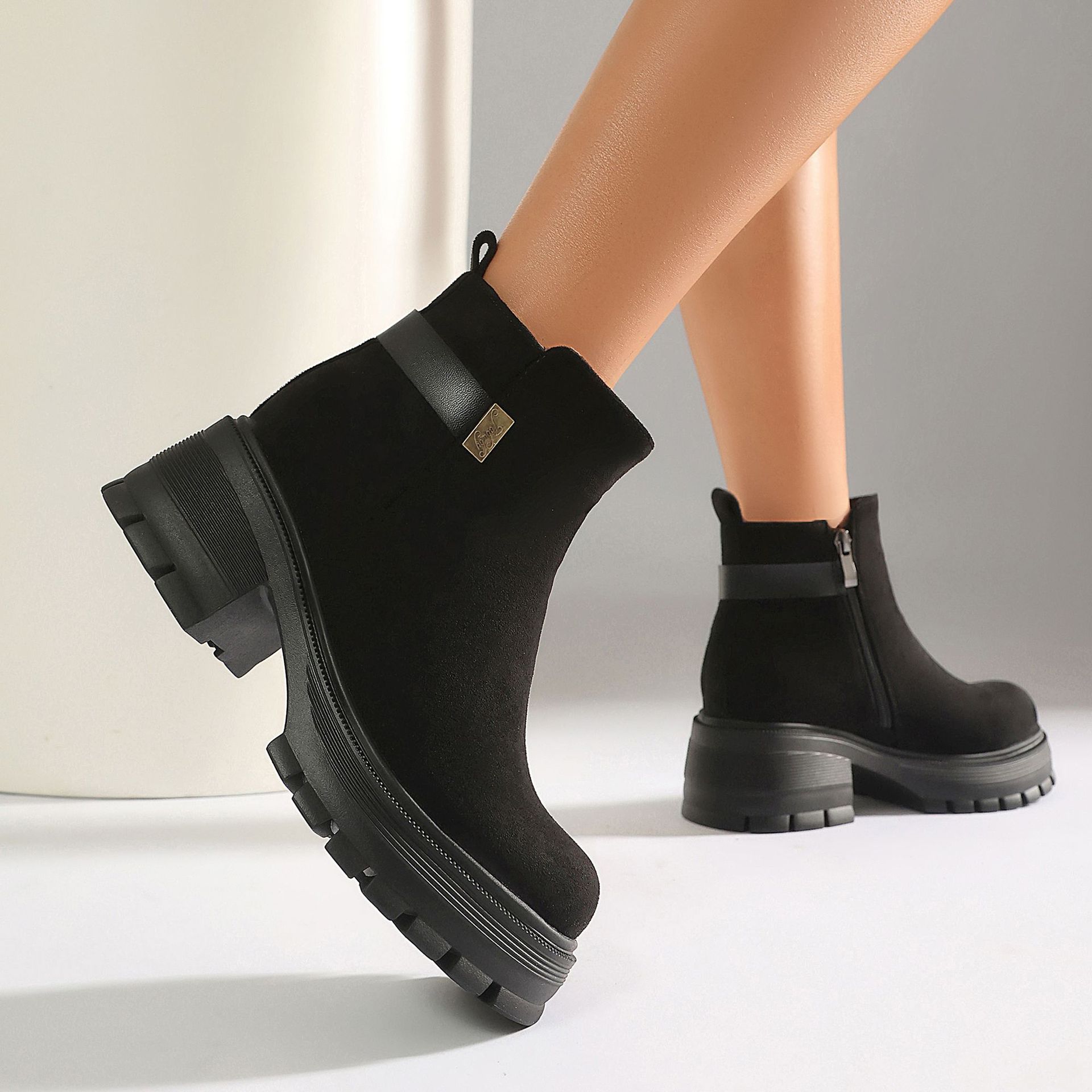 Black faux suede ankle boots – front view on model showing full boot and outfit styling