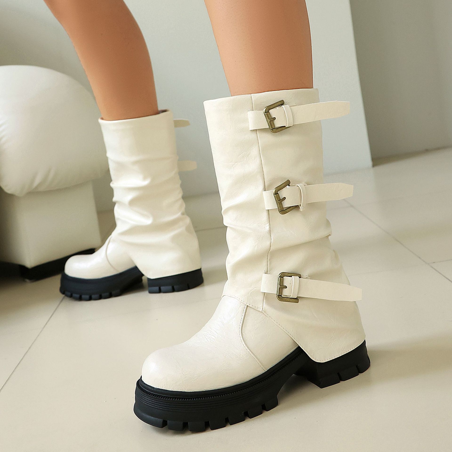 Women's triple buckle moto boots in black – back view showing side zipper and lug sole detail