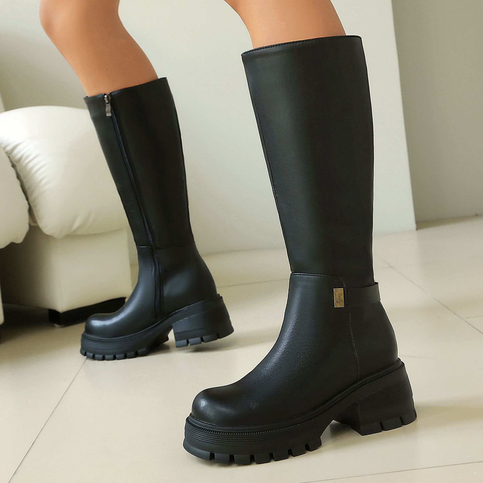 Black PU knee-high boots – close-up of glossy PU finish and gold hardware detail
